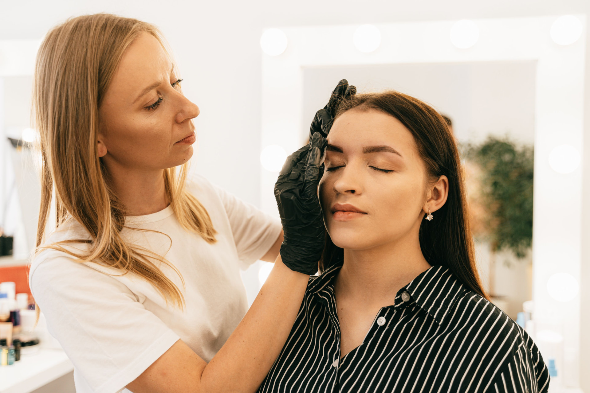 Brow artist working with a client in a bright studio