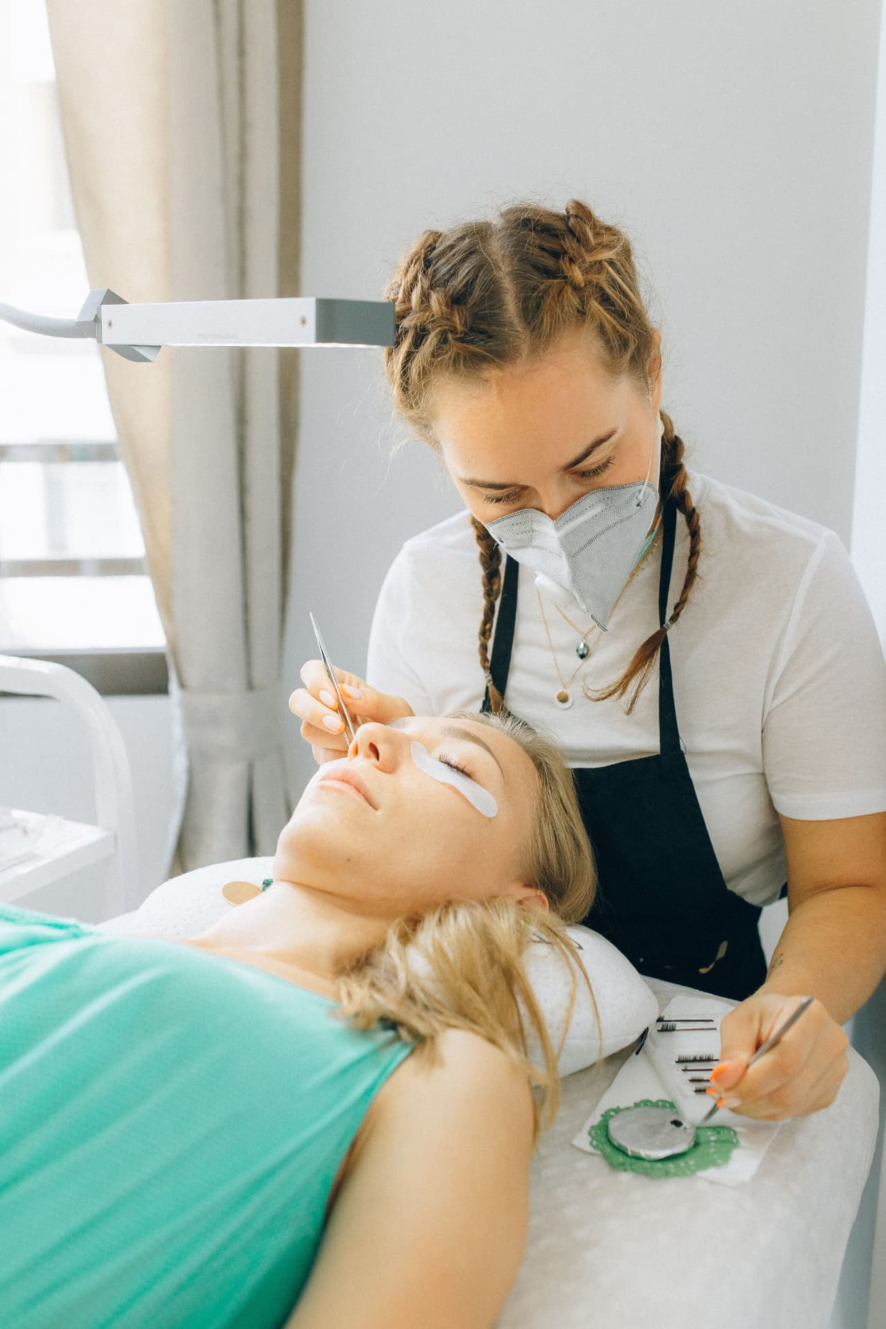 Lash artist working on a client in a clean studio